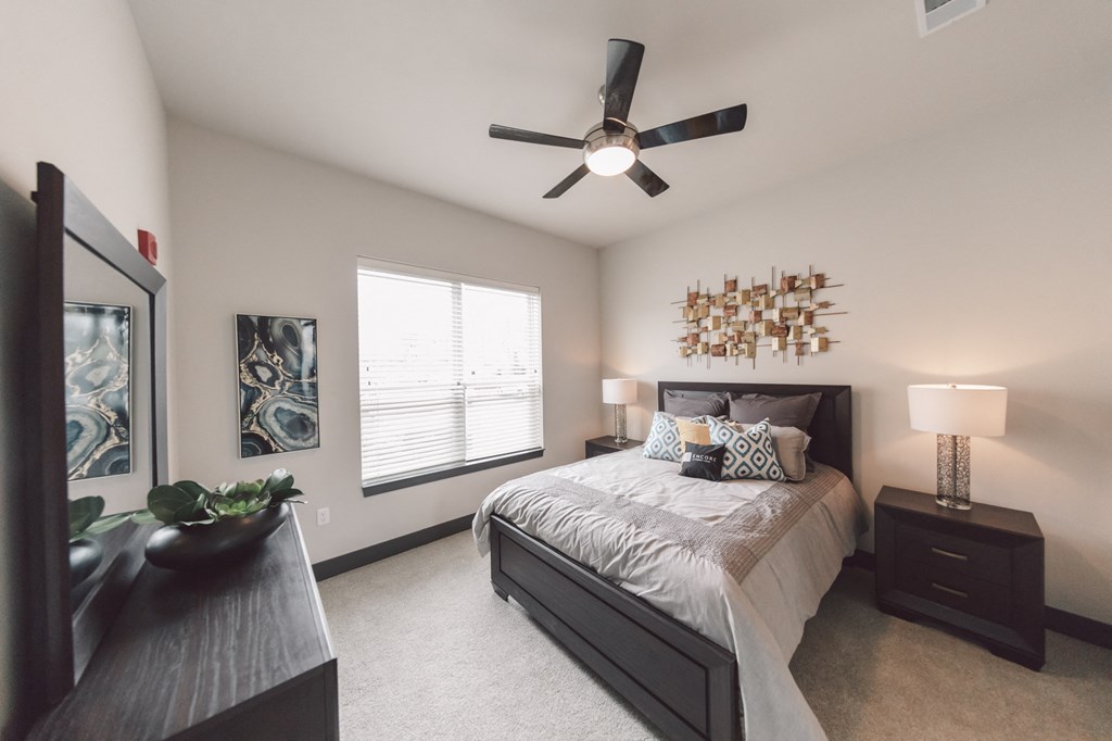 a bedroom with a large bed and a ceiling fan