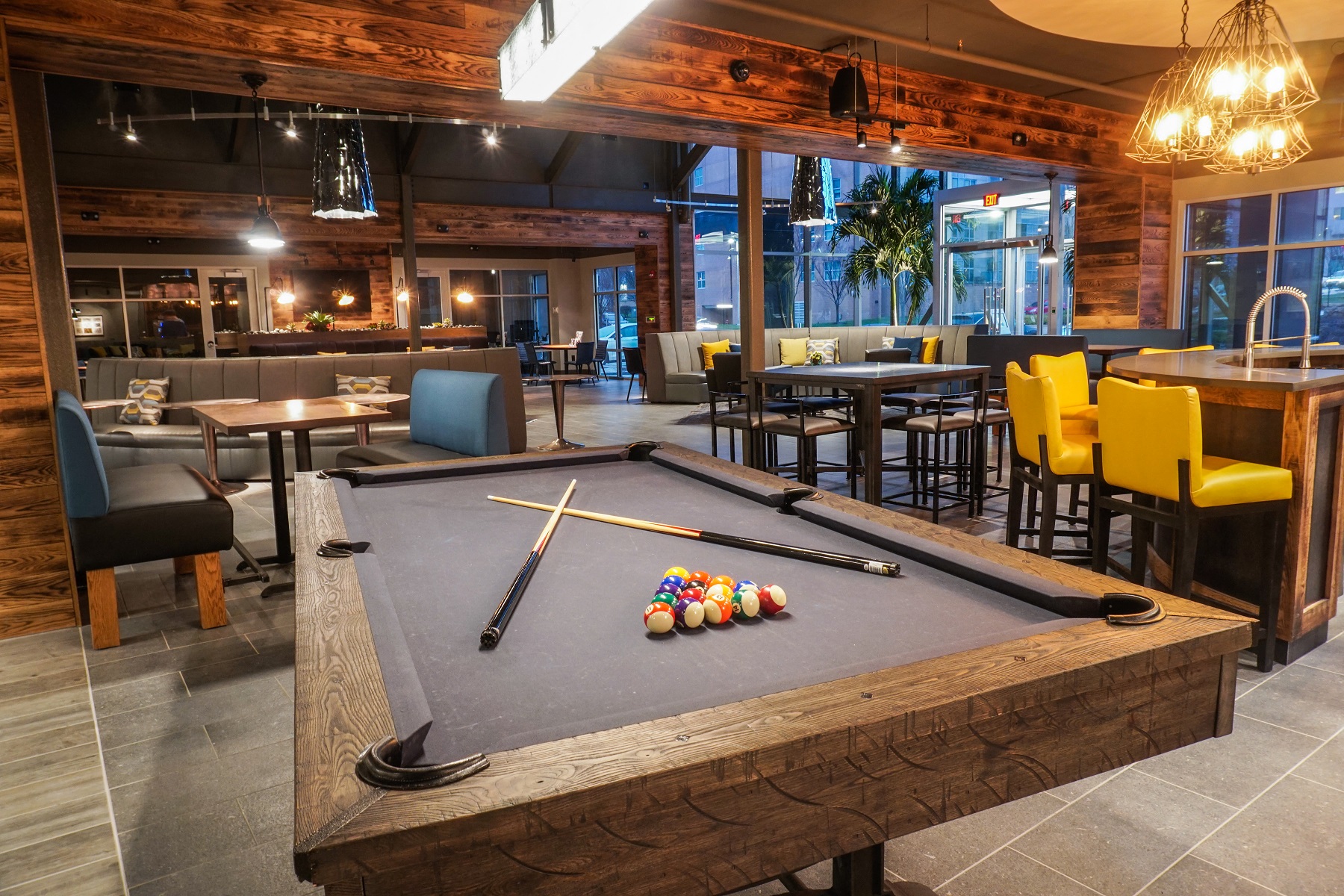 a pool table in a restaurant with tables and chairs
