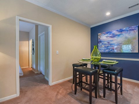 a dining room with a table and chairs and a painting on the wall