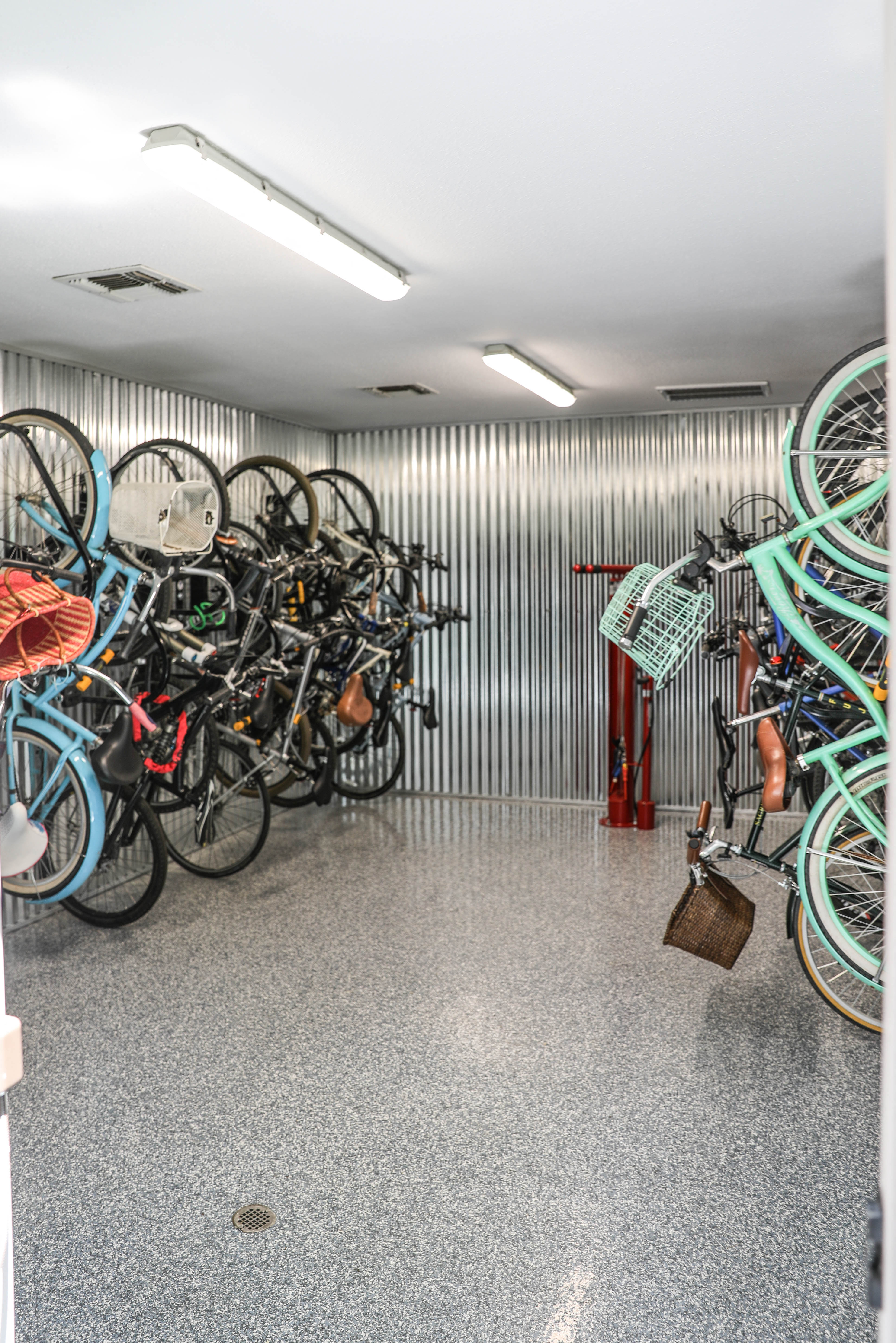 the storage room is filled with bikes and helmets on the wall