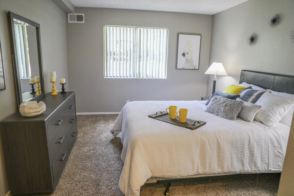 a bedroom with a bed and a dresser and a window