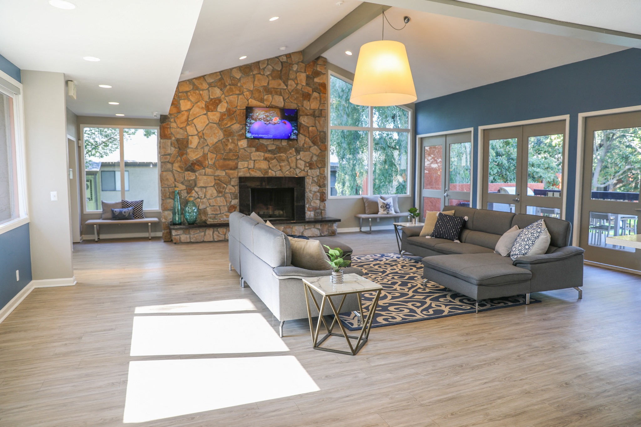 a living room with a stone fireplace and couches