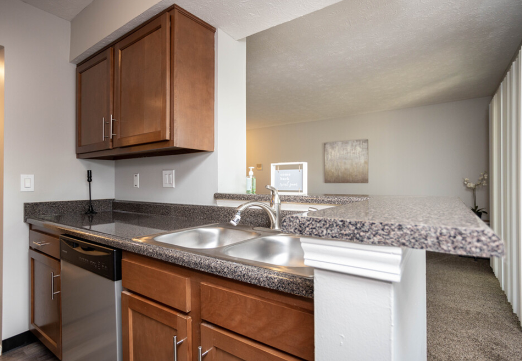 a kitchen with granite counter tops and a stainless steel sink