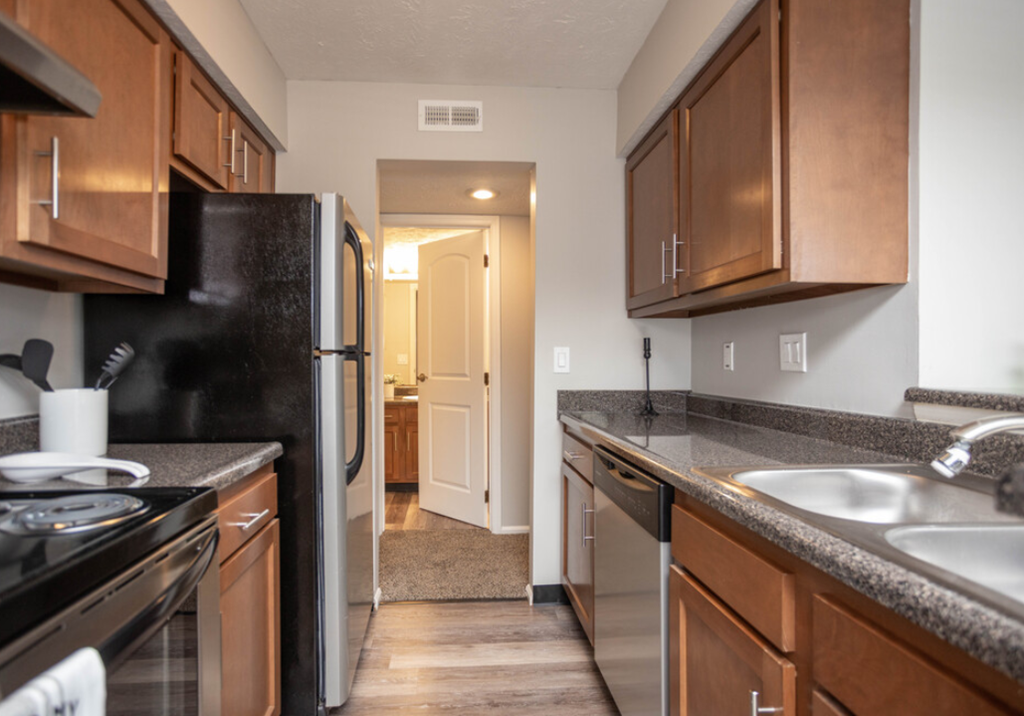 a kitchen with wooden cabinets and a black refrigerator