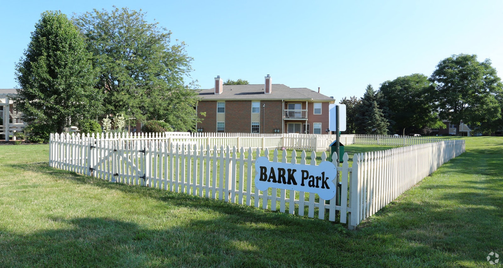 a white fence with a sign on it in front of a house