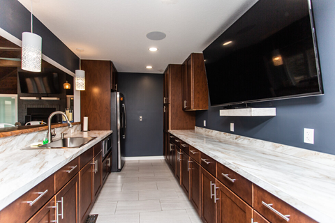 a large kitchen with marble counter tops and wooden cabinets