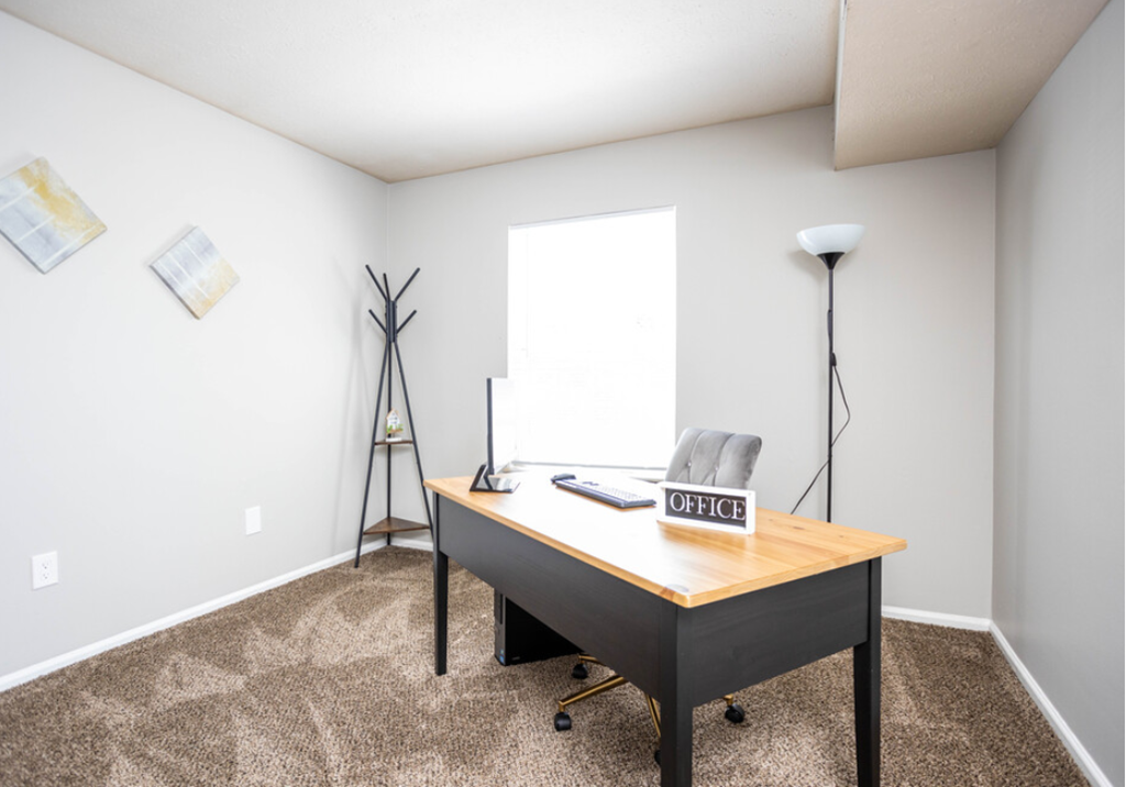 a home office with a desk and a window