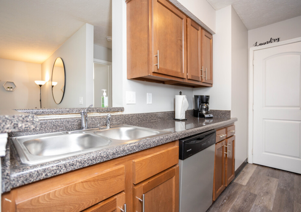 a kitchen with wood cabinets and granite counter tops and a sink