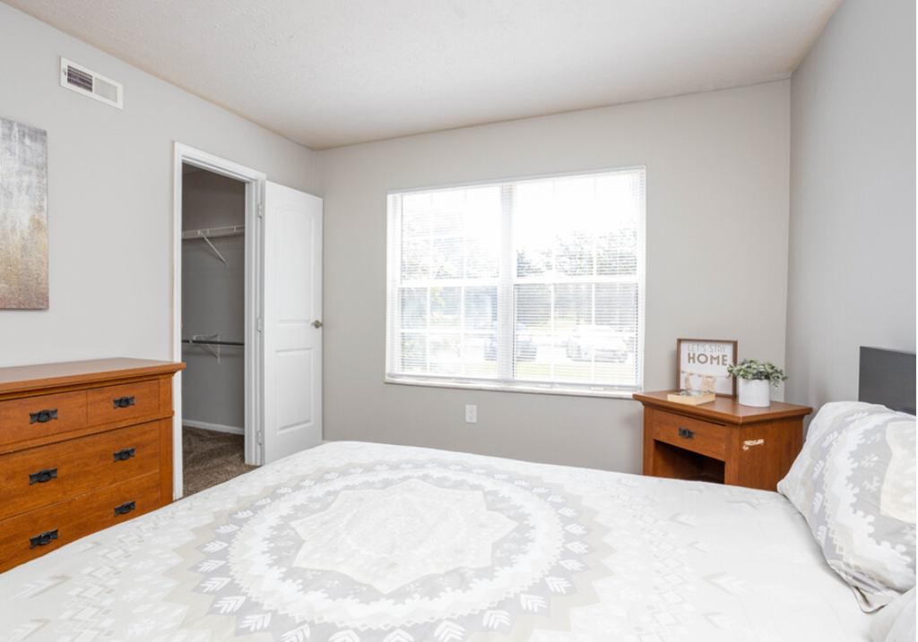 a bedroom with a large bed and a window