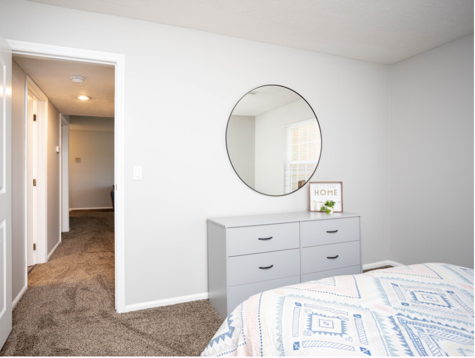 a bedroom with a bed and a mirror