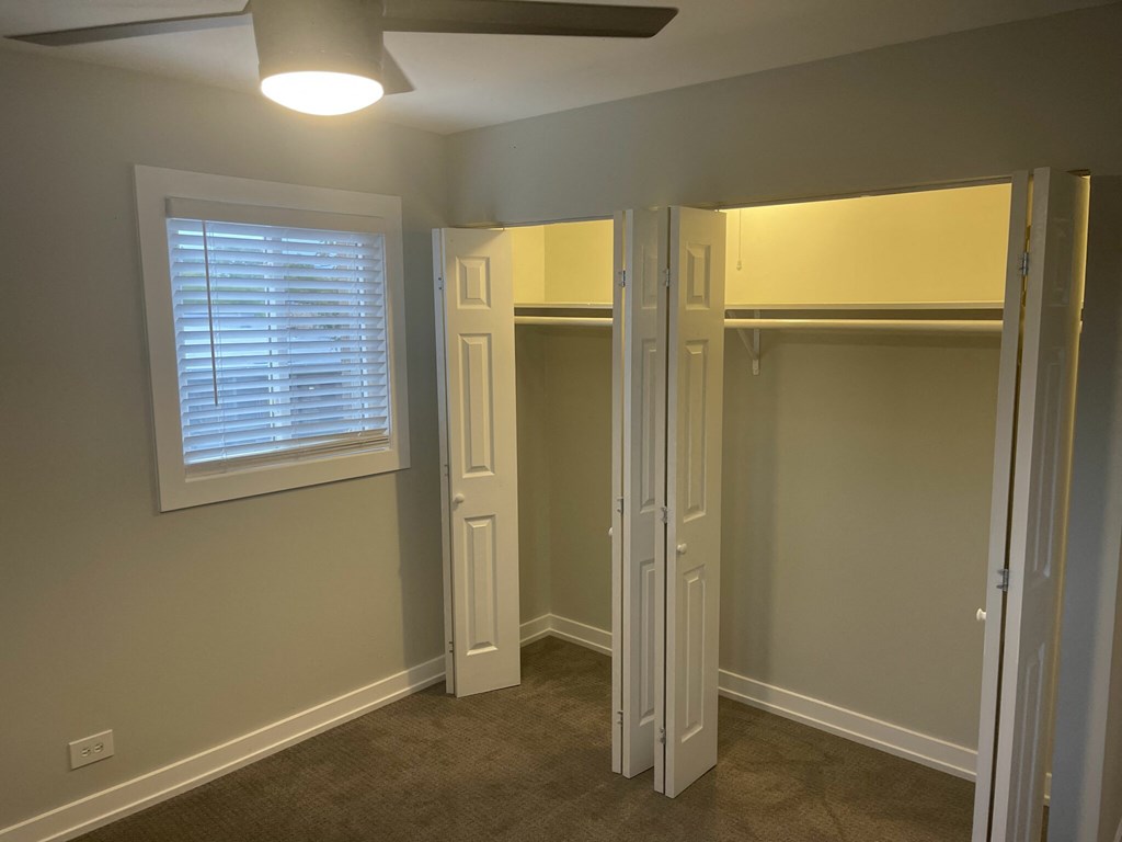 a walk in closet with two doors and a window