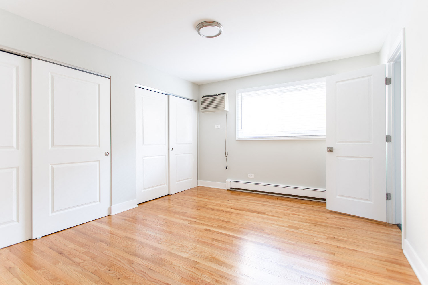 an empty room with white doors and a window