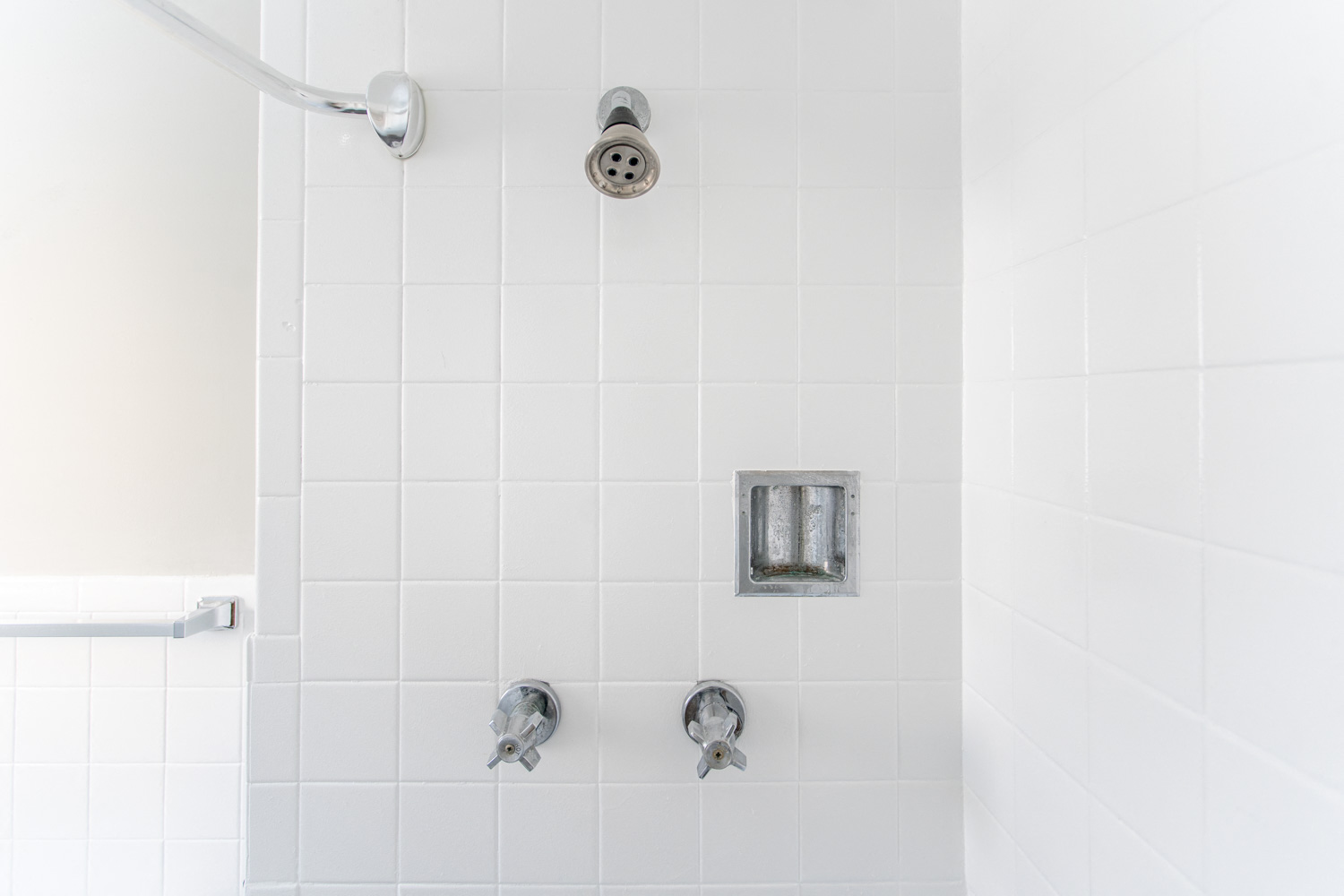 a white tiled shower in a bathroom