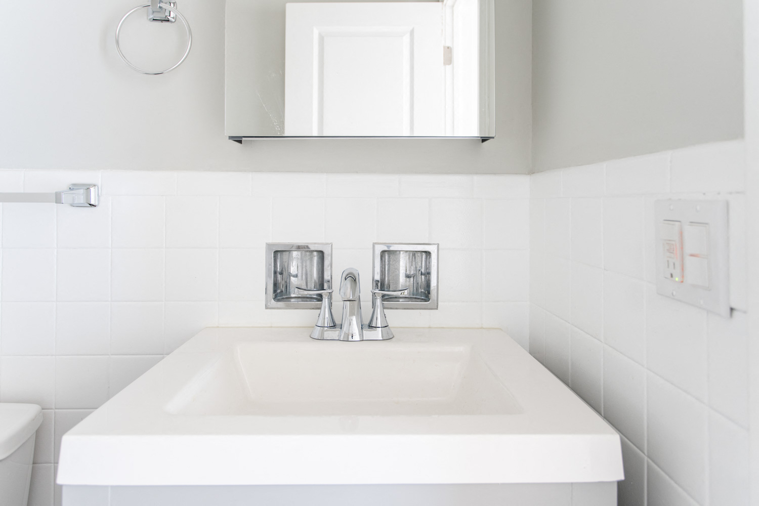 a white bathroom with a sink and a mirror