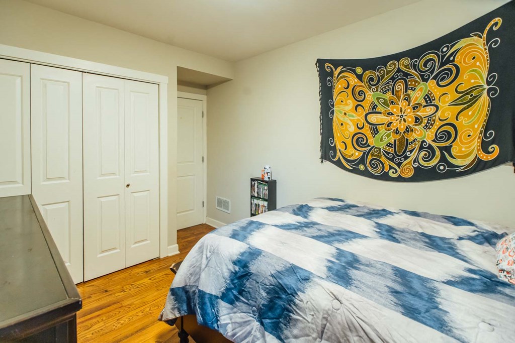 a bedroom with a bed and a tapestry on the wall