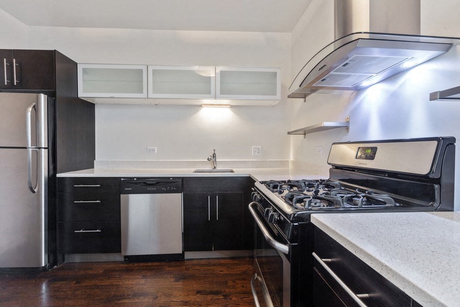 an empty kitchen with a stove and a refrigerator