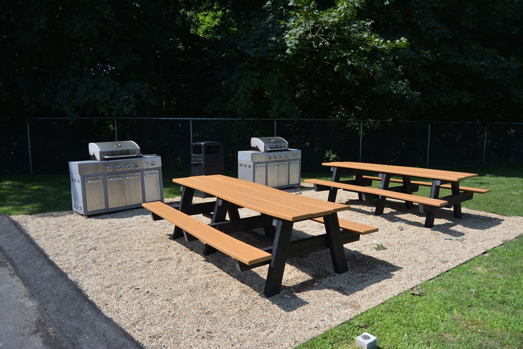 Outdoor picnic table & grill area at Oxford Apartments Stoughton