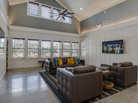 A living room with a grey couch and a ceiling fan.
