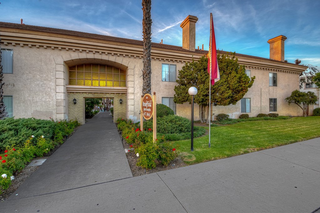 a building with a flag and a sidewalk in front of it