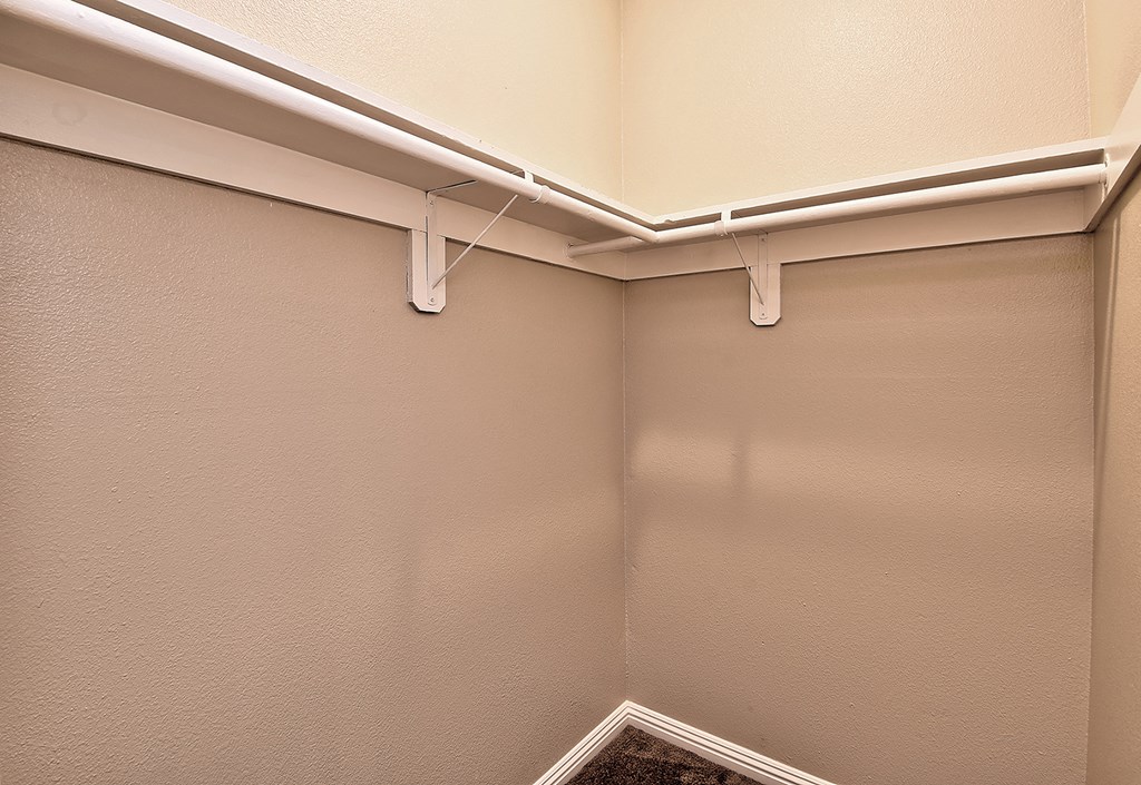 an empty closet in a room with white walls and white fixtures