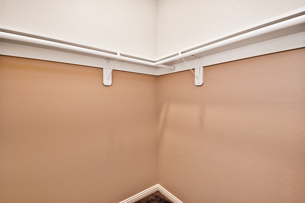 the living room of an apartment with a ceiling fan and a closet