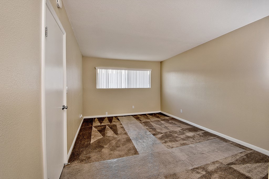 an empty room with carpet and a window