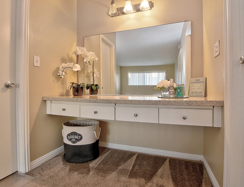 a bathroom with a vanity and a mirror and a trash can