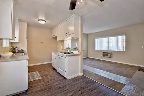 the kitchen and living room of a renovated apartment with white appliances