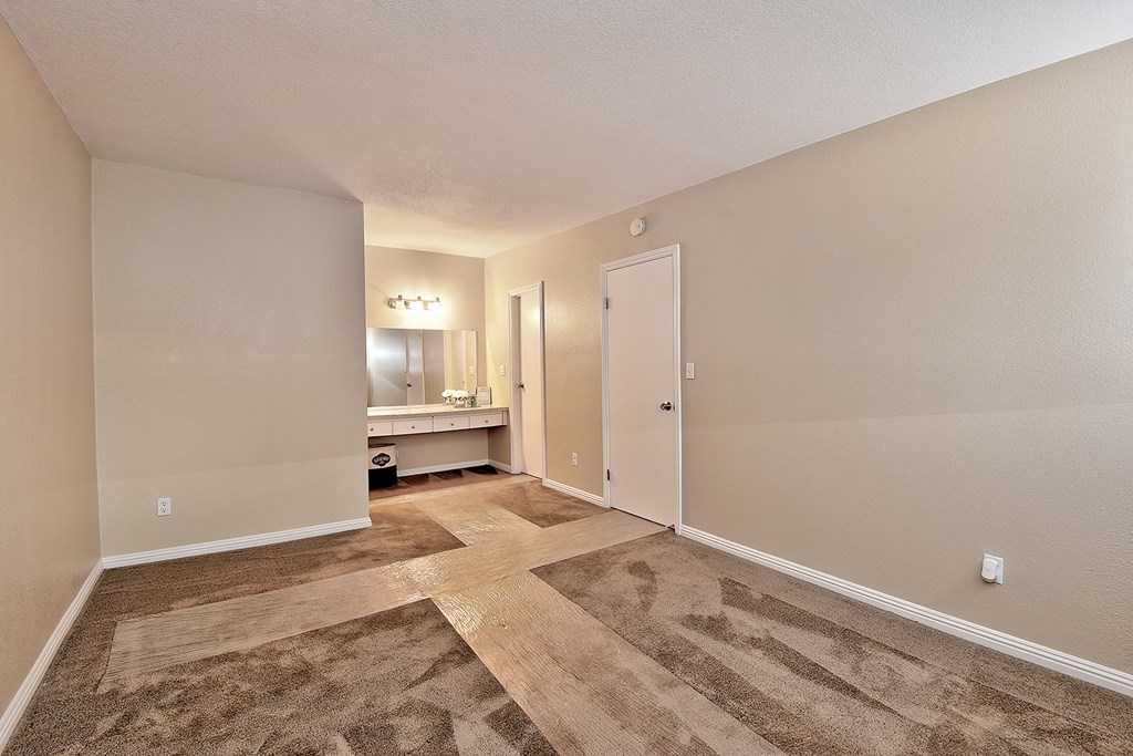 a spacious living room with a door to a bathroom