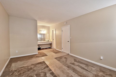 a spacious living room with a door to a bathroom