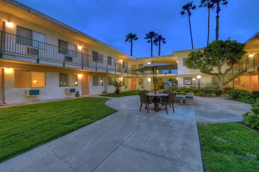 a patio with a table and chairs in a courtyard