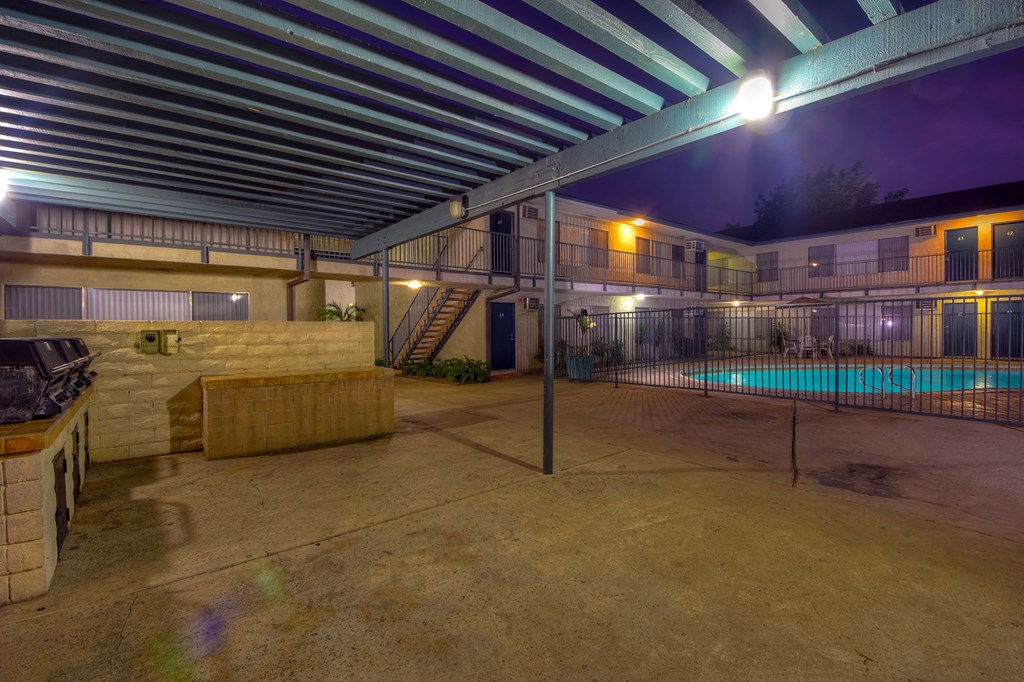 the pool area of a building with a swimming pool at night