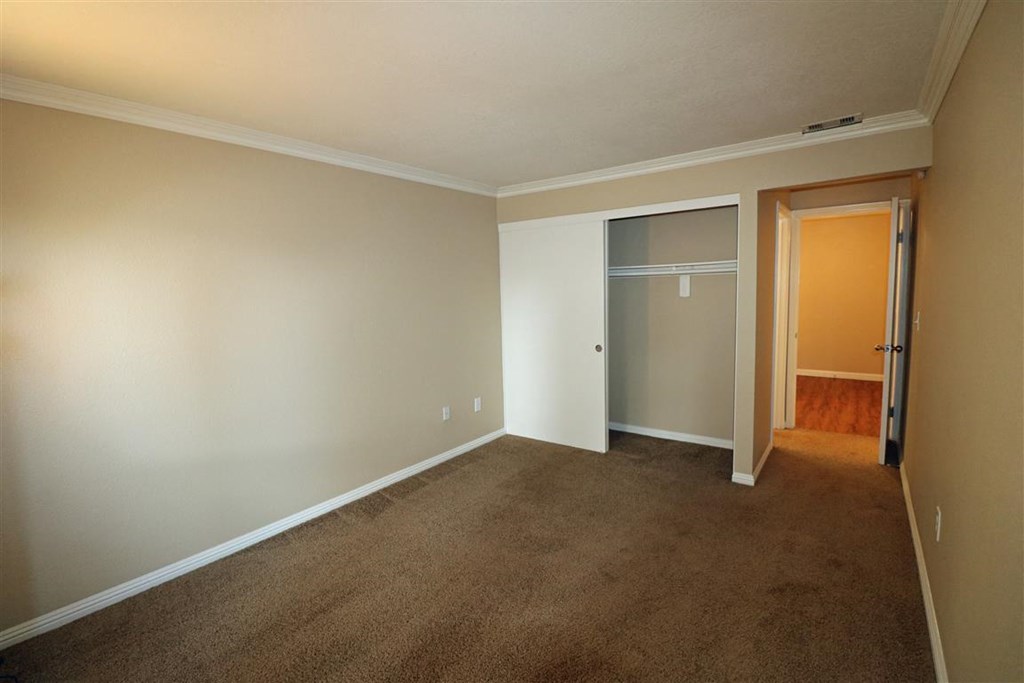 an empty living room with a door to a closet