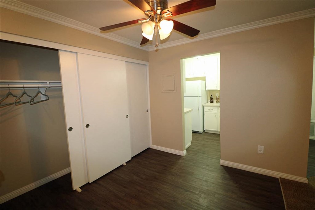 a living room with a ceiling fan and a closet