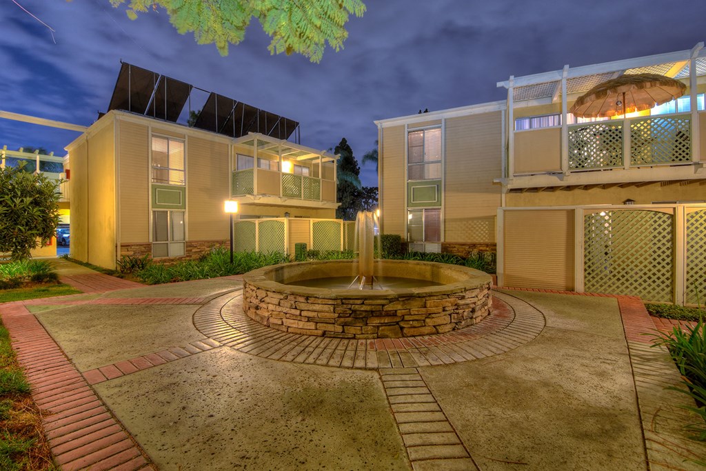 a courtyard with a fountain in the middle of some buildings