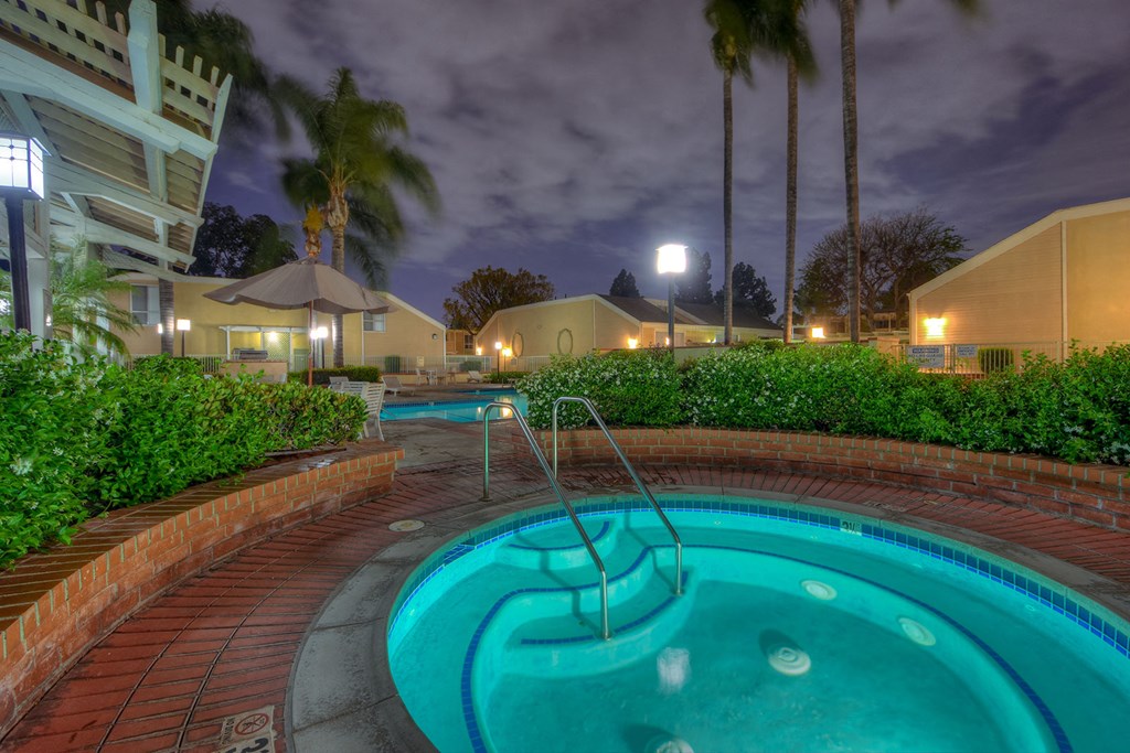 a swimming pool at night with palm trees