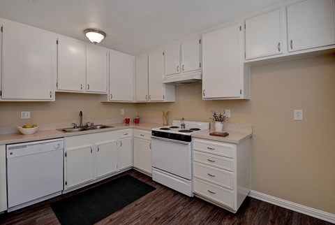 a kitchen with white cabinets and a stove and sink