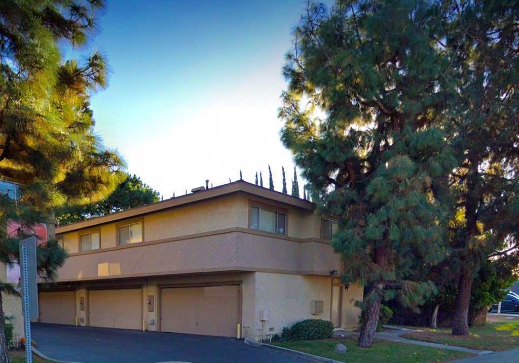 a building with a parking lot and trees