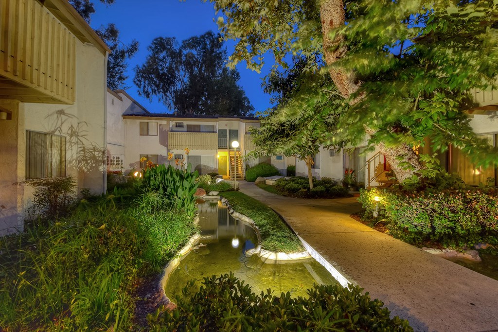 a yard with a water feature in front of a house
