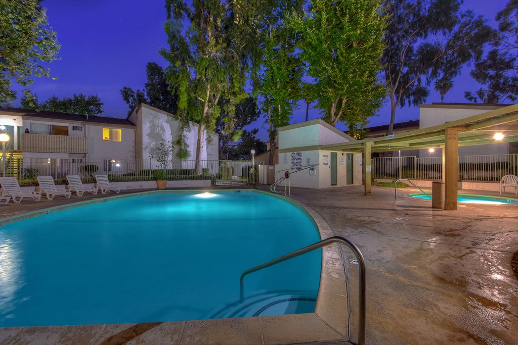 a swimming pool at night in front of a building