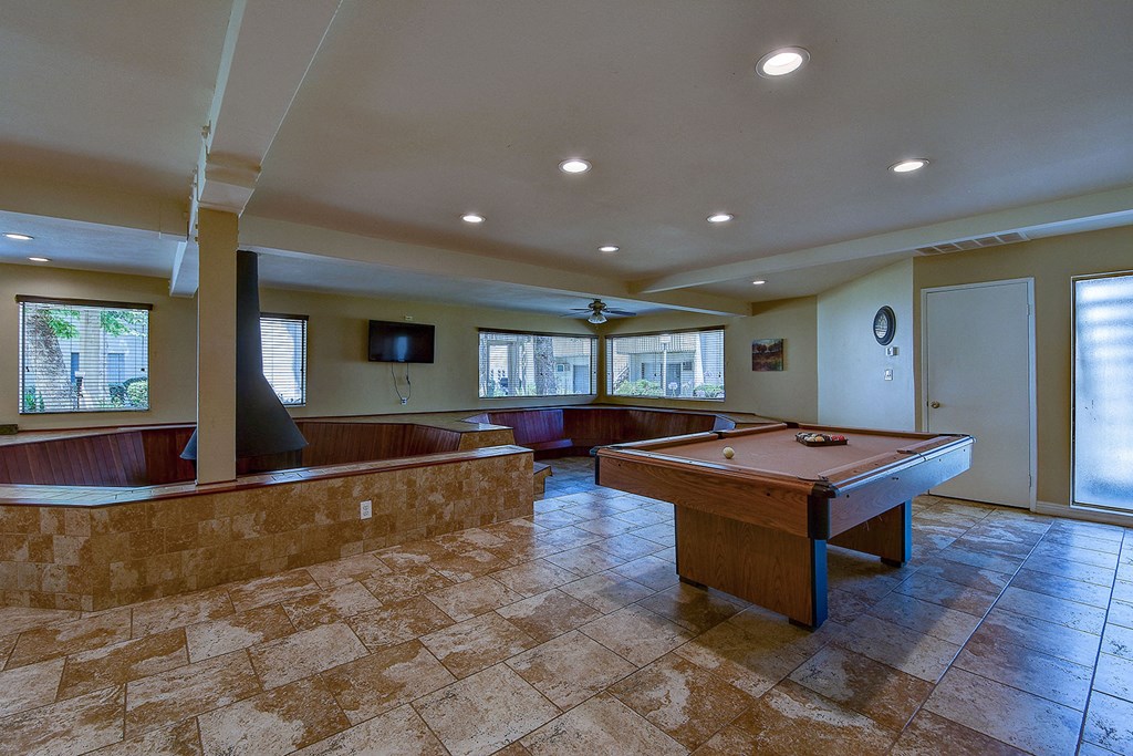 a game room with a pool table and a tv