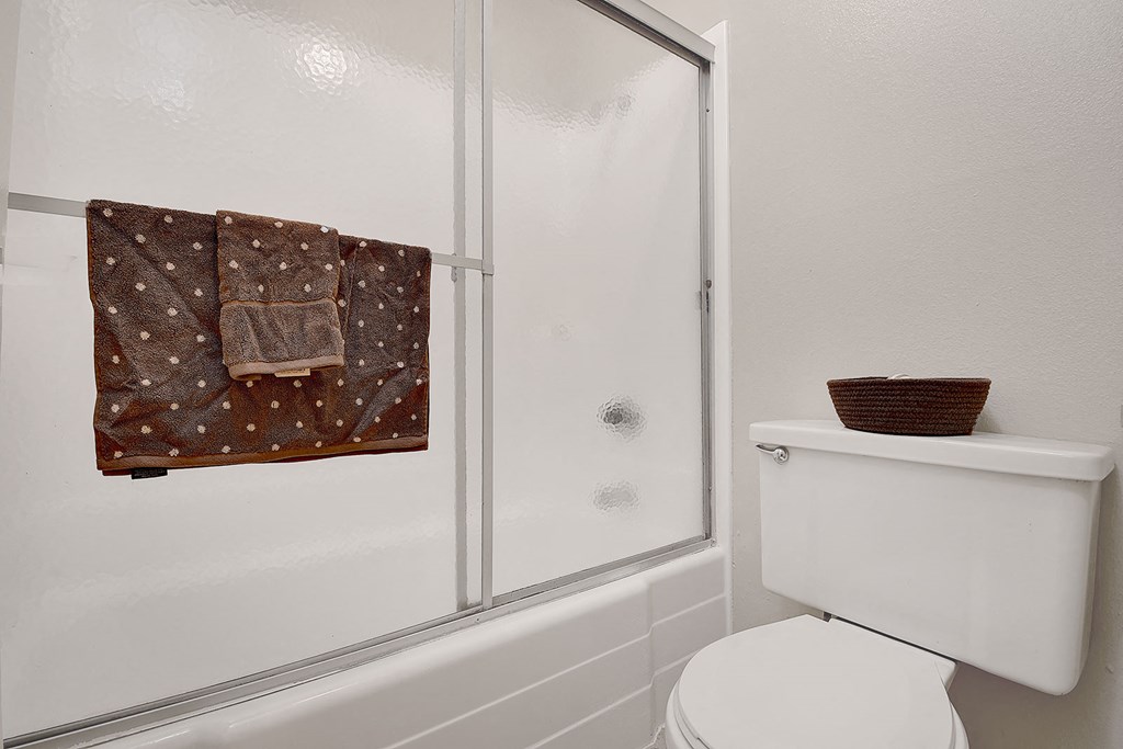 a white bathroom with a shower and a toilet