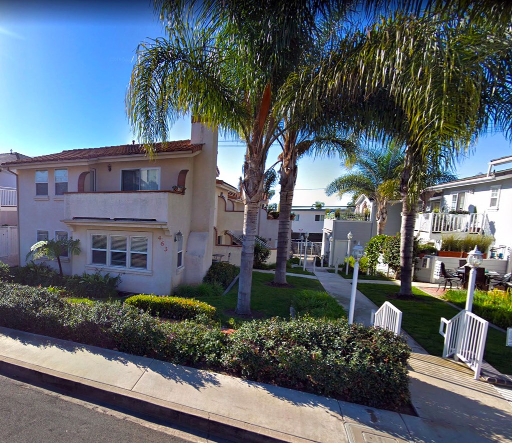 a street with palm trees in front of houses