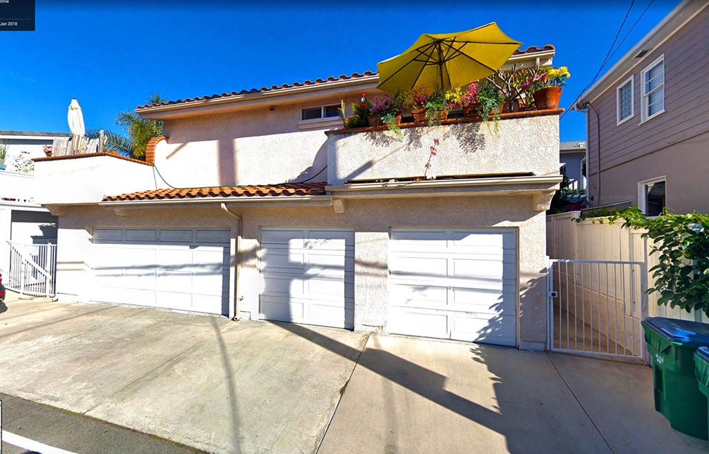 a garage with white doors and a yellow umbrella on top of it