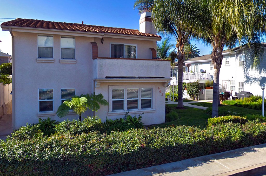 a white house with palm trees in front of it