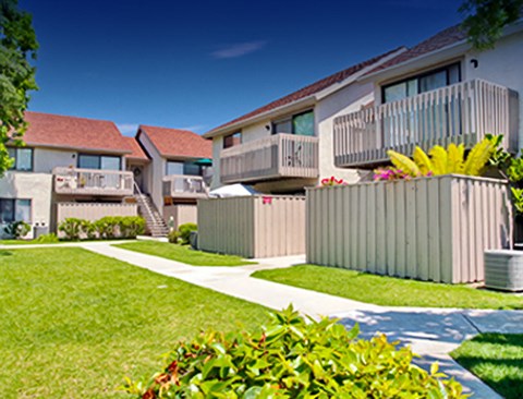 a row of houses with balconies and a lawn