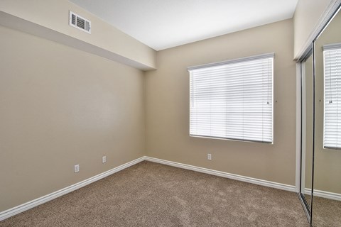 Empty carpeted bedroom with window and mirrored closet at TERRAZA DEL SOL Apartments, California, 91730
