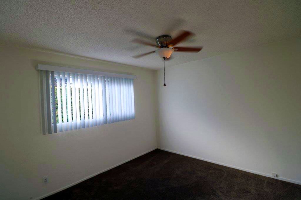 a living room with a ceiling fan and a window