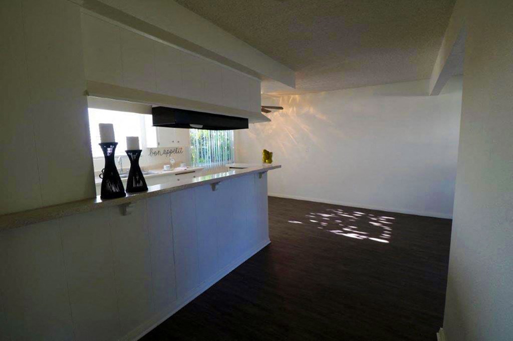 a white kitchen with a counter and a window