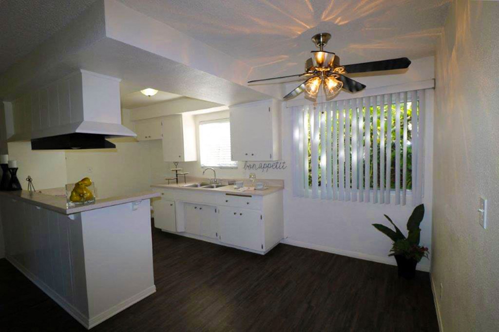 an empty kitchen with a ceiling fan and a sink